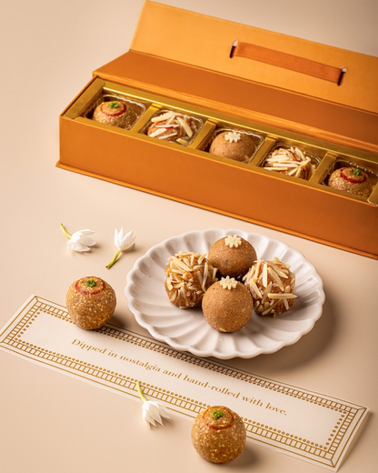 TLW Phulkari-inspired winter gift box featuring assorted traditional sweets including TLW Nuts Laddoo, Til Gur Laddoo, and Atta Panjiri Laddoo, a premium festive hamper celebrating North Indian winter flavours and heritage.