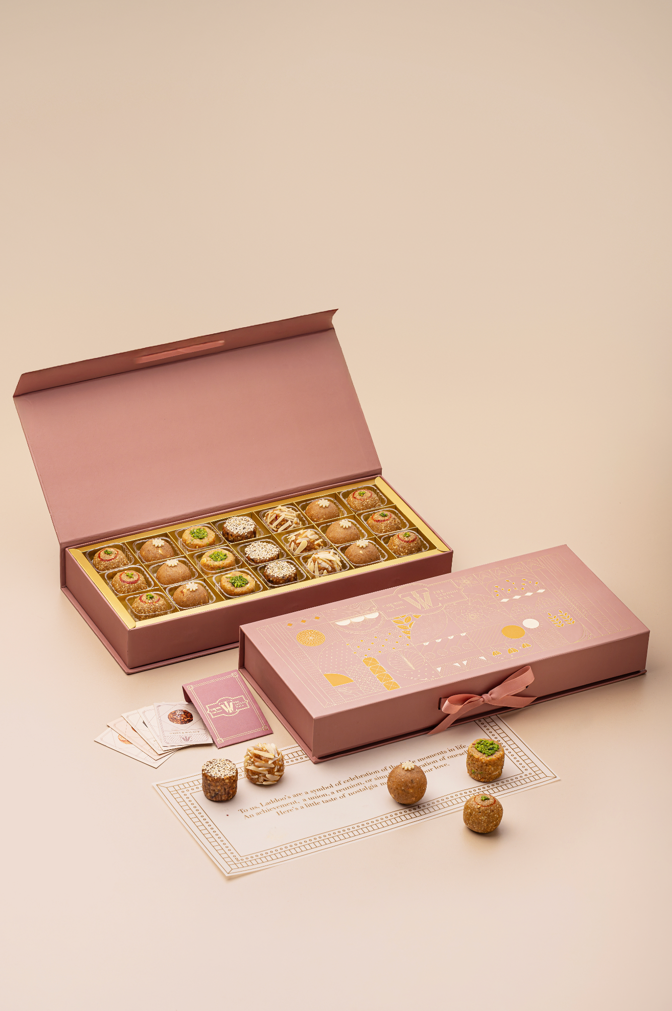 TLW Jodha Box inspired by Rajput princess Jodha Bai, featuring an assorted royal laddoo collection including Til Gur, Atta Panjiri, TLW Nuts, Dates & Walnuts, and Mewari Churma laddoos in an elegant premium gift box.