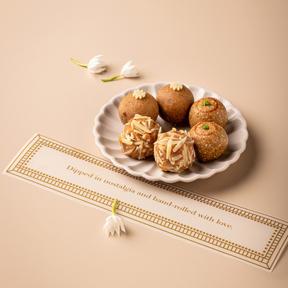 TLW Phulkari-inspired winter gift box featuring assorted traditional sweets including TLW Nuts Laddoo, Til Gur Laddoo, and Atta Panjiri Laddoo, a premium festive hamper celebrating North Indian winter flavours and heritage.